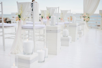 Fototapeta na wymiar luxury wedding decorations with gentle rose and white tones, number of white chair decorated with flowers