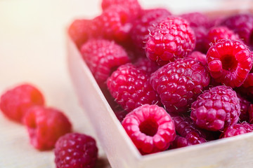 Ripe red raspberries in wooden box