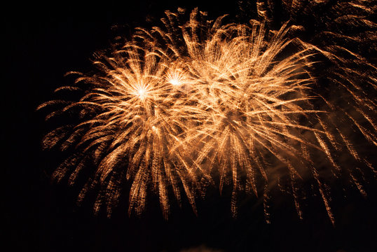 Multiple yellow fireworks exploding