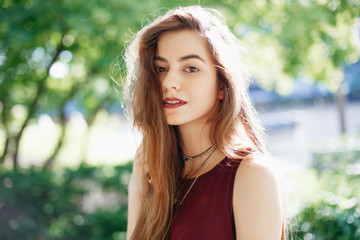 Portrait of smiling innocent Caucasian middle eastern blonde young beautiful woman with long hair and brown eyes, looking in camera. Girl with with natural beauty emotions outside on summer day.