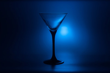 Cocktail glass for martini on a dark blue background with backlight