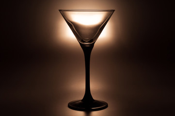 Cocktail glass for martini on a dark background with backlight