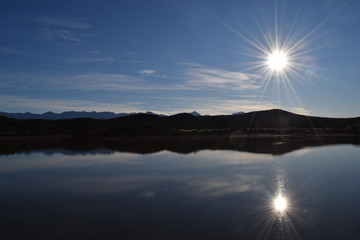 Sun over mountains and lake in South Africa