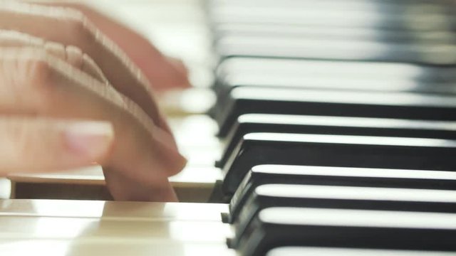 Girl playing on piano close-up 4K