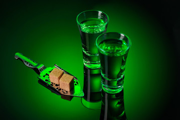 Alcohol Absinthe with a sugar cubes and spoon on black