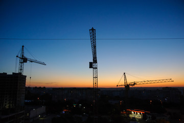 tower cranes silhouette at construction site