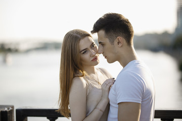 Fototapeta premium Portrait of young couple in love, enjoying the sunset in city