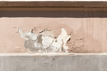 Peeling mortar - plaster damaged of moisture on facade of old house.