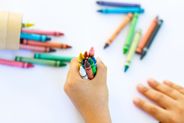 Naklejka premium child's hands with lots of colorful wax crayons