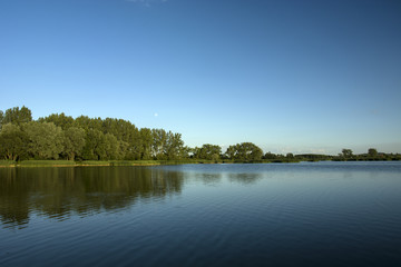 Fototapeta na wymiar Large, blue lake and trees on the shore
