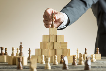 Businessman placing a chess piece on blocks