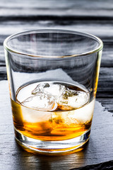 glass of whiskey on dark wooden background
