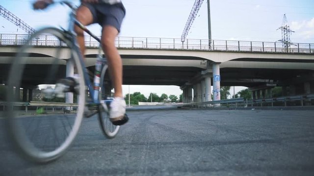 Group of cyclists riding fixed gear bikes on the road, steadycome shot, slow motion