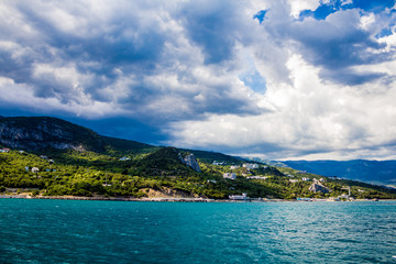 Sea shore against the background of mountains and sky with clouds, Yalta Crimea