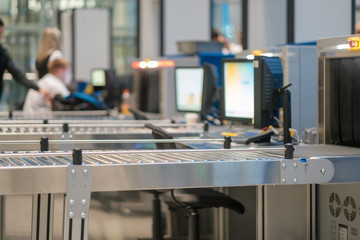 Security check gates with computer screens and conveyor belt at the entrance of airport