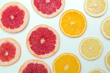 Fototapeta na wymiar slices of oranges, lemons and grapefruits on vintage white table. Citrus fruit background. healthy eating with natural vitamins. Top view with copy space
