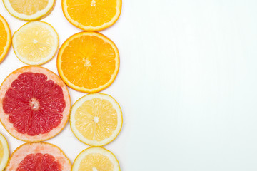 slices of oranges, lemons and grapefruits on vintage white table. Citrus fruit background. healthy eating with natural vitamins. Top view with copy space