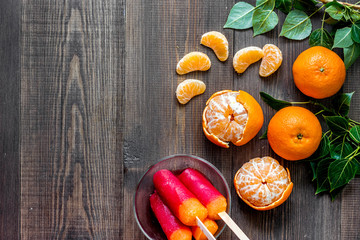 Mandarins and citrus ice cream on wooden table background top view copyspace