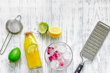 Bottle with fresh lemonade and fruits on wooden background top view copyspace