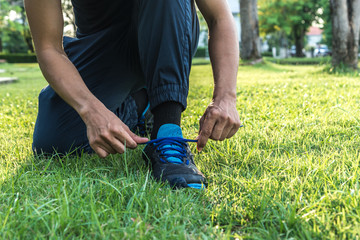 Fototapeta na wymiar young man runner tying shoelaces