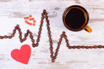 Cardiogram line made of coffee grains, cup of coffee and supplement pills