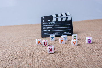 Letter cubes beside a director clapper board