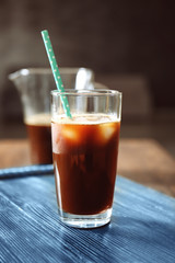 Glass with cold brew coffee and straw on table