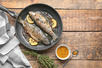 Composition with tasty fried trout fish on wooden background