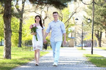 Fototapeta premium Beautiful young couple walking in park on sunny day
