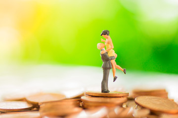 Miniature couple : Lovers embrace love on the stack coin.