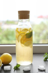 Bottle of fresh lemonade on window sill