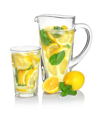 Jug and glass with tasty refreshing lemonade on white background