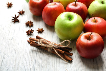 Apples with cinnamon sticks on wooden background