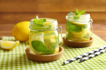 Jars of fresh lemonade on wooden background