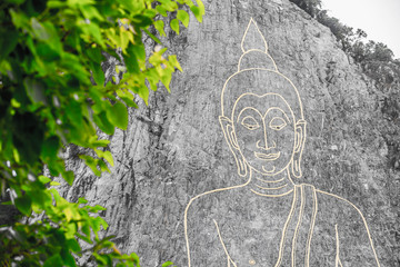 Golden Big Buddha on the mountain Khao Chi Chan, Pattaya, Thailand whit green leaf foreground
