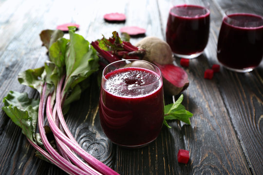 Glasses with fresh beet smoothies on wooden table