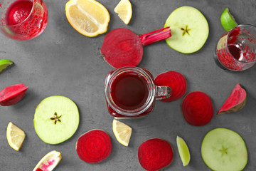 Beetroot smoothie in mason jar and some ingredients on grey table