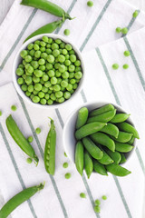 Bowls with fresh green peas on table