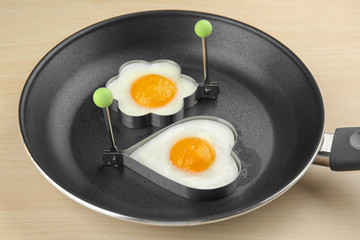 Frying pan with tasty over easy eggs in molds