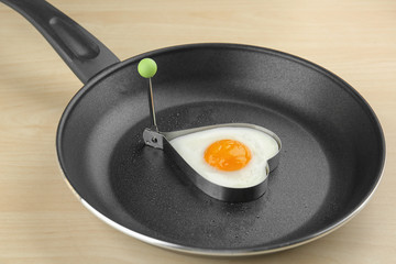 Frying pan with tasty over easy egg in mold