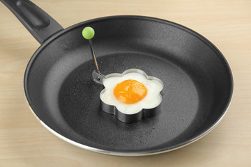 Frying pan with tasty over easy egg in mold