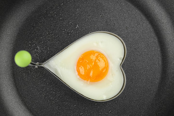 Frying pan with tasty over easy egg in mold