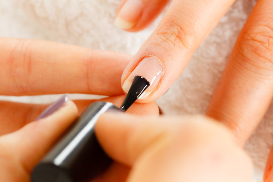 Woman in beauty salon getting manicure done.