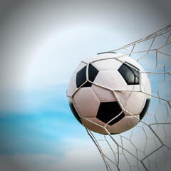 Soccer football in Goal net with the sky field.
