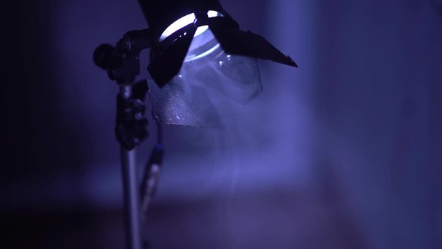 studio lamp on the blue background. film spotlight lantern in the stage fog
