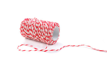 Red and white baker's twine spool isolated on white background