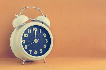 Retro alarm clock on brown background with copy space