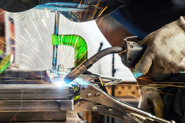 man welds a metal welding machine