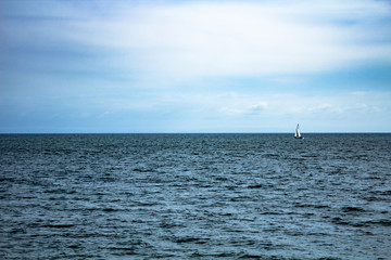 Monochromatic view of ocean with lone sailboat