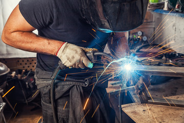man weld  a metal  with a  welding machine